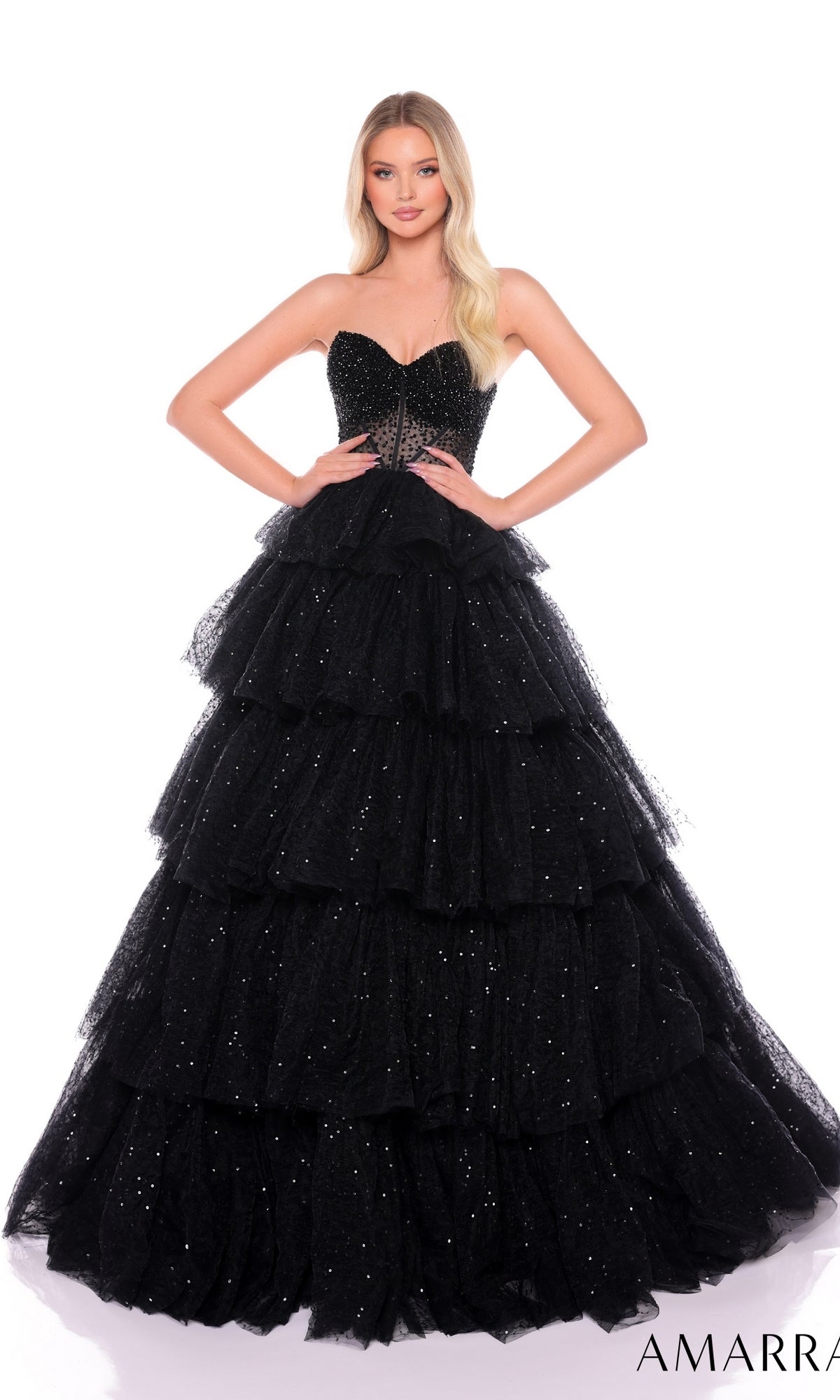 A woman poses in the Long Formal Dress 88131 by Amarra, a strapless ballgown featuring glitter tulle, layered ruffles, and sparkling embellishments, set against a white background.